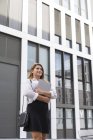 Портрет усміхненої бізнес-леді з ноутбуком на відкритому повітрі — стокове фото