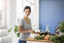 Mujer preparando comida saludable en su cocina - foto de stock