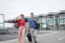 Sorridente coppia a piedi fuori aeroporto — Foto stock