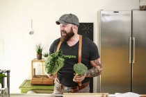 Veganer wählt Gemüse in seiner Küche — Stockfoto