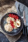Boulettes sucrées remplies de prunes avec croûte de noix de coco et cannelle et groseilles rouges — Photo de stock