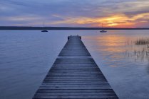 Wooden jetty at sunset at Lake Ammersee, Fuenfseenland, Bavaria, Germany. — Stock Photo