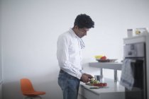 Uomo in piedi in cucina preparare le verdure per la cottura — Foto stock