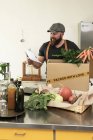 Зрелый человек с доставкой органических овощей в картон — стоковое фото