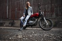 Ridere giovane donna con moto — Foto stock