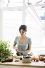 Woman preparing healthy food in her kitchen — Stock Photo