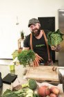 Veganer wählt Gemüse in seiner Küche — Stockfoto