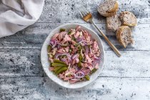 Sausage salad with cheese, gherkins and baguette — Stock Photo
