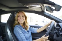 Sorrindo mulher dirigindo carro — Fotografia de Stock