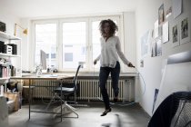 Businesswoman in office training with skipping rope — Stock Photo