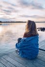 Giovane donna seduta al lago Inari, guardando la vista, Finlandia — Foto stock