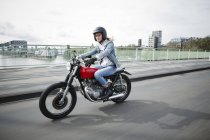 Allemagne, Cologne, jeune femme à moto sur le pont — Photo de stock