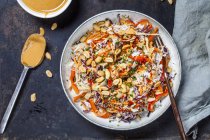 Warm rice salad with grated vegetables, peanut sauce and peanuts — Stock Photo