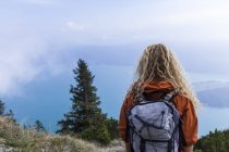 Jovem mulher caminhando nas montanhas da Baviera, olhando para o Lago Walchensee — Fotografia de Stock