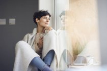 Relaxed woman at home sitting at the window — Stock Photo
