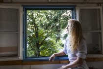 Молода жінка, що дивиться з вікна причепа — стокове фото