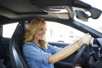 Sorrindo mulher dirigindo carro — Fotografia de Stock