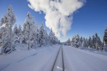 Germany, Saxony-Anhalt, Harz National Park, Brocken, rail tracks of Harz Narrow Gauge Railway in winter, clouds of steam — Stock Photo