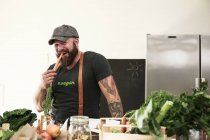 Вегетарианец греет морковку на кухне — стоковое фото