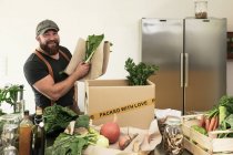 Зрелый человек с доставкой органических овощей в картон — стоковое фото