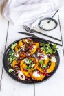 Autumnal salad with fried pumpkin, lentils, radicchio, pomegranate seeds, leaf salad and parsley with dressing — Stock Photo