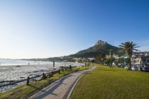 Afrique du Sud, Bord de l'eau de Camps Bay avec la tête de lions en arrière-plan, banlieue du Cap — Photo de stock
