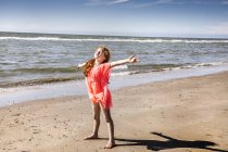 Pays-Bas, Zandvoort, fille debout sur la plage avec les bras tendus — Photo de stock