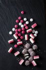 Verschiedene rosa und weiße Bonbons, Pfefferminzbonbons, Schokoknöpfe, Fondantkugeln — Stockfoto