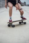 Image recadrée de femme équitation sculpteur skateboard sur une promenade — Photo de stock