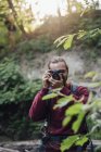 Giovane escursionista che scatta foto in una foresta — Foto stock