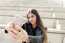Jovem mulher tomando uma selfie nas escadas — Fotografia de Stock