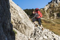 Uomo escursioni in montagna in terreni rocciosi — Foto stock