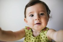 Porträt eines kleinen Mädchens, das seine Arme auf weißem Hintergrund ausstreckt — Stockfoto