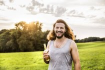 Порта щасливий чоловік п'є пиво в сільському пейзажі — стокове фото