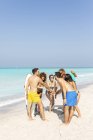 Grupo de amigos en la playa apilándose las manos - foto de stock