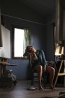 Молодой художник сидит в ателье — стоковое фото
