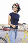 Щаслива молода жінка з велосипедом у місті. — стокове фото