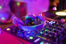 Headphones on illuminated mixing board — Stock Photo