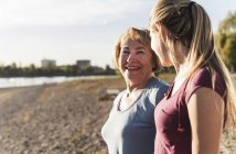 Fit grandmother and grandmother enjoying the sun at the river — Stock Photo