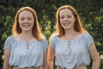 Усміхнені червонячи близнюки дивляться на камеру — стокове фото