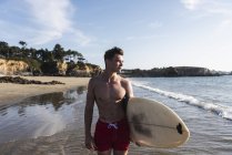 France, Bretagne, jeune homme avec planche de surf debout à la mer — Photo de stock