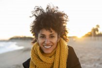 Porträt einer glücklichen Frau am Strand, die einen gelben Schal trägt — Stockfoto