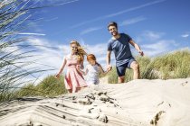 Netherlands, Zandvoort, happy family with daughter in beach dunes — Stock Photo