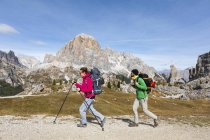Italia, Cortina d 'Ampezzo, dos personas haciendo senderismo en la zona montañosa Dolomitas - foto de stock