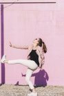 Felice giovane donna che si muove davanti al muro rosa — Foto stock