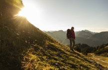 Mujer de pie en las montañas, disfrutando de la vista - foto de stock