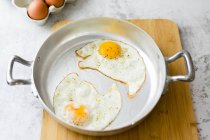 Two fried eggs with pepper in pan — Stock Photo