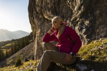 Женщина, сидящая в горах, наслаждаясь видом — стоковое фото