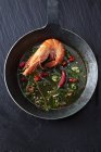 Prawn with herbs, chili and garlic in iron pan — Stock Photo