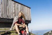 Mujer riendo tomando un descanso en una cabaña de montaña - foto de stock